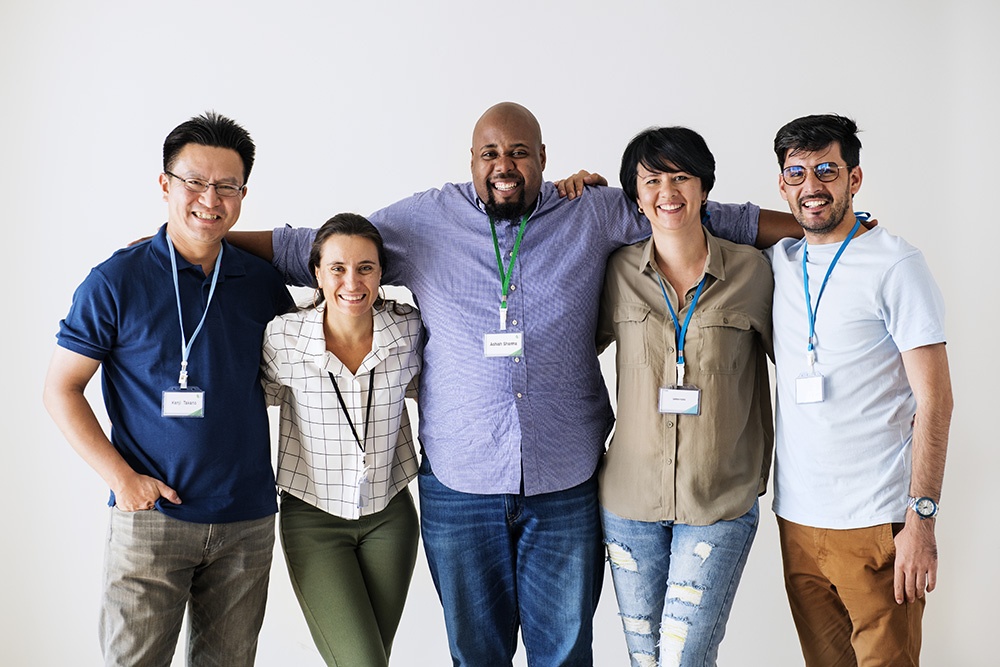 A diverse group of smiling workers with name tags