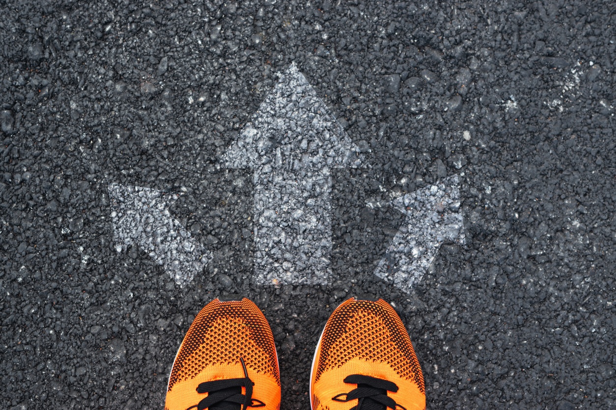 Arrows on a road with a pair of feet at the start of the arrows