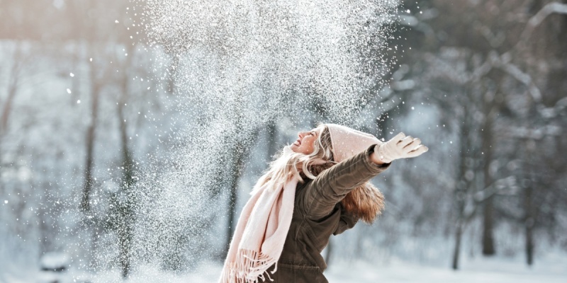 Joyous woman outside with snow falling on her